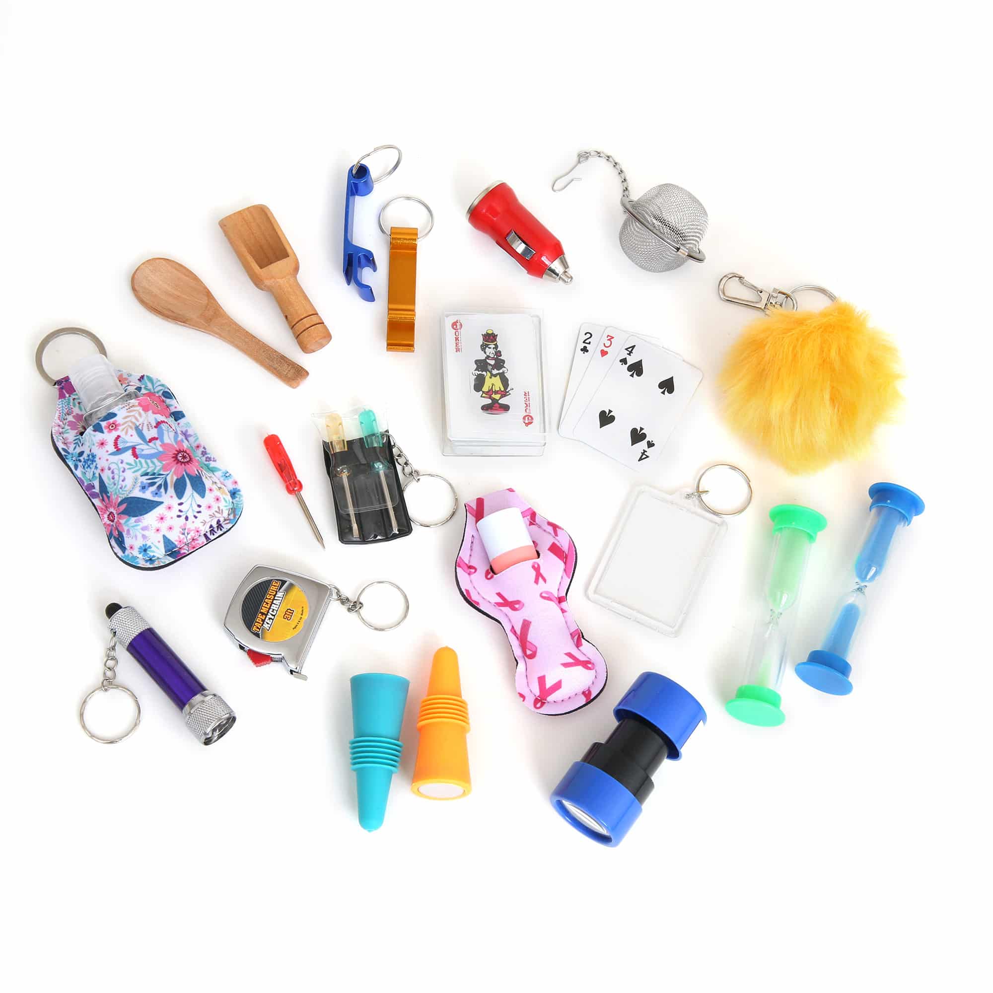 Assorted small objects scattered on a white surface, including playing cards, a yellow fluffy keychain, a floral pouch, and various colorful plastic tools and accessories.